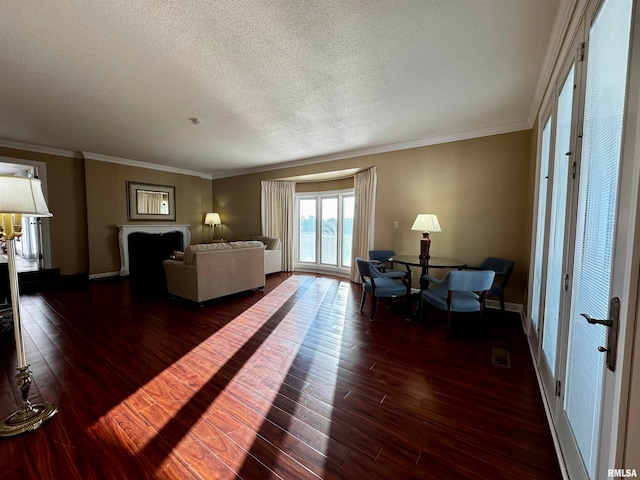 living room featuring a textured ceiling, ornamental molding, and dark hardwood / wood-style floors