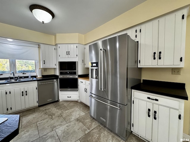 2001 Wigwam Hollow Rd, Macomb, IL 61455 - kitchen featuring appliances with stainless steel finishes, dark countertops, white cabinetry, and light stone finish floors