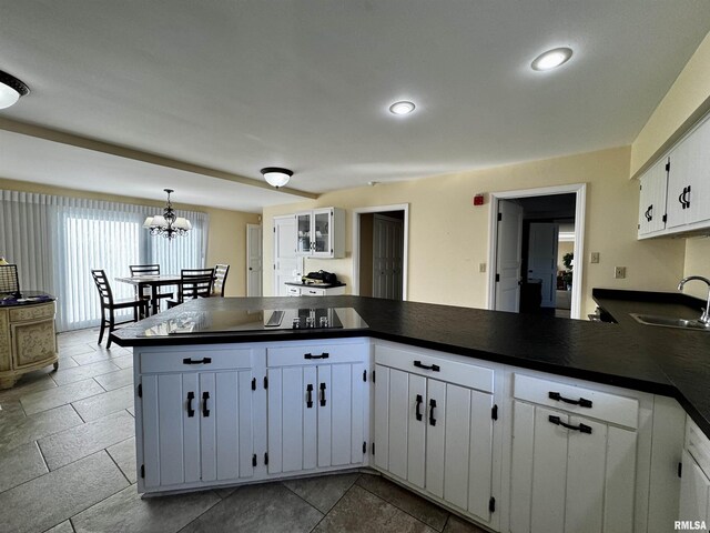 2001 Wigwam Hollow Rd, Macomb, IL 61455 - kitchen featuring dark countertops, a peninsula, white cabinetry, and a chandelier