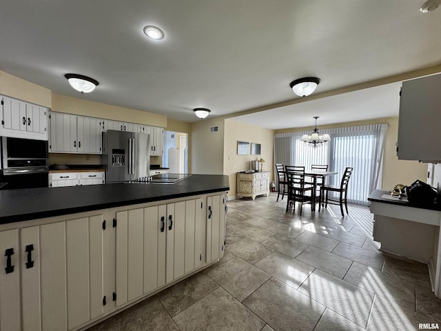 2001 Wigwam Hollow Rd, Macomb, IL 61455 - kitchen featuring high quality fridge, dark countertops, black electric cooktop, wall oven, and a chandelier