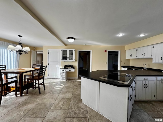 kitchen featuring black electric cooktop, white cabinetry, kitchen peninsula, decorative light fixtures, and a chandelier