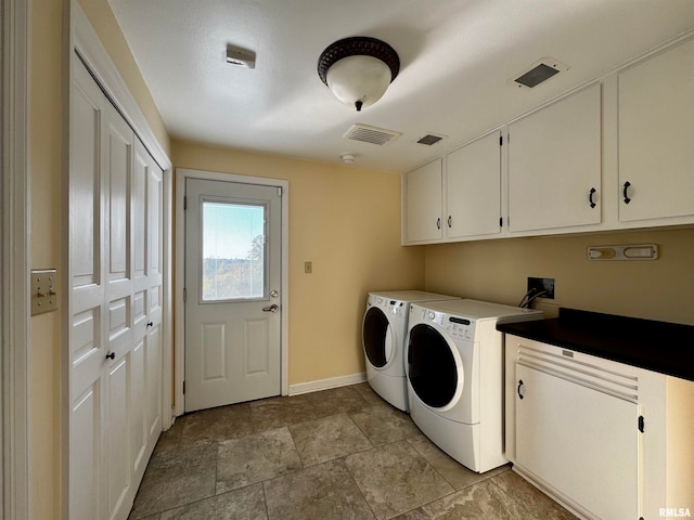 washroom featuring separate washer and dryer and cabinets