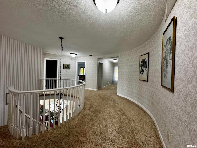 hallway with carpet floors and a textured ceiling