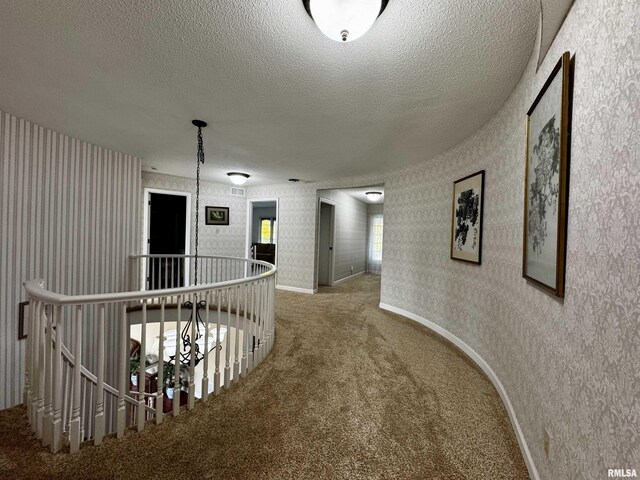 2001 Wigwam Hollow Rd, Macomb, IL 61455 - hall with carpet flooring, an upstairs landing, a textured ceiling, and wallpapered walls