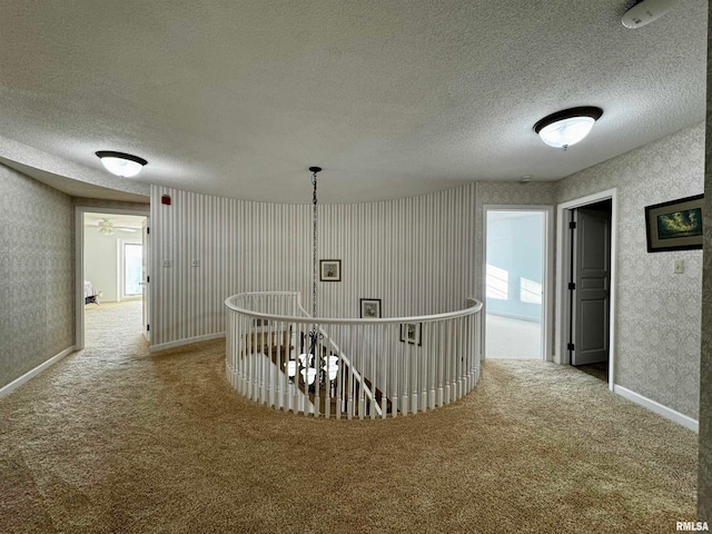 hallway featuring a textured ceiling and carpet flooring