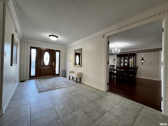 2001 Wigwam Hollow Rd, Macomb, IL 61455 - tiled foyer entrance featuring ornamental molding, a chandelier, a textured ceiling, and wallpapered walls