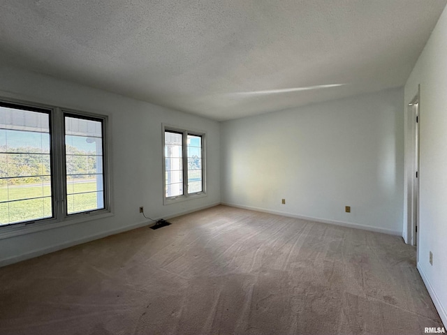 carpeted empty room with a textured ceiling