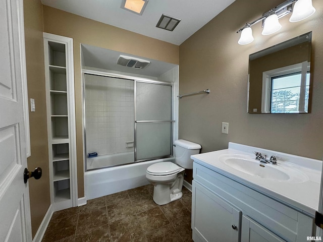 full bathroom featuring combined bath / shower with glass door, tile patterned floors, vanity, and toilet