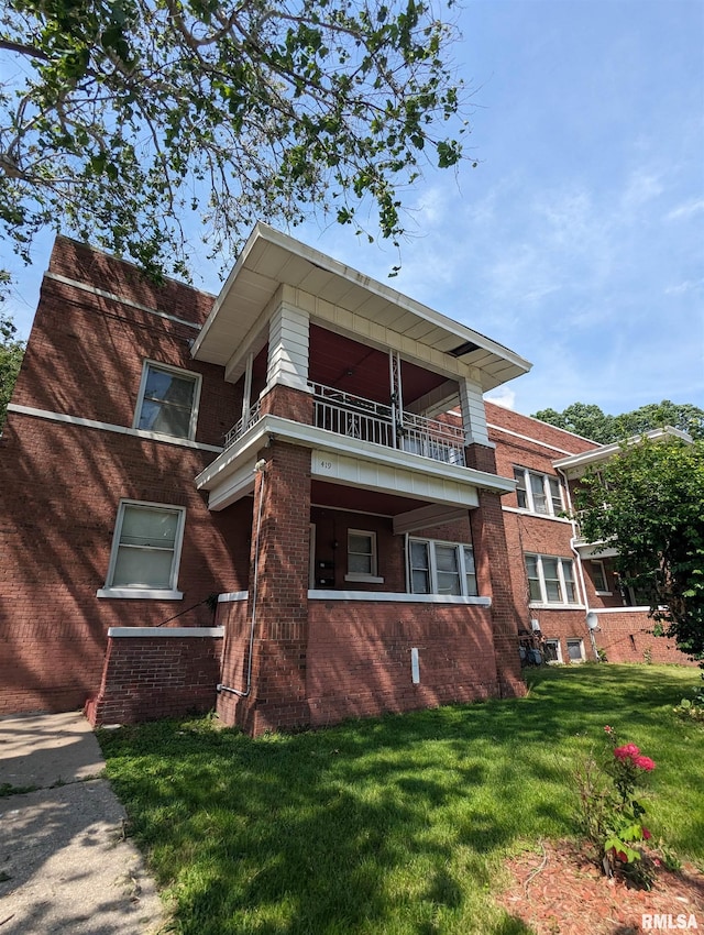 exterior space with a balcony and a lawn