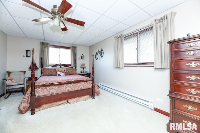 bedroom featuring a drop ceiling, light colored carpet, ceiling fan, and a baseboard heating unit