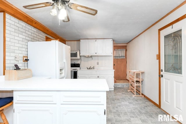 kitchen with kitchen peninsula, ornamental molding, white appliances, sink, and white cabinets