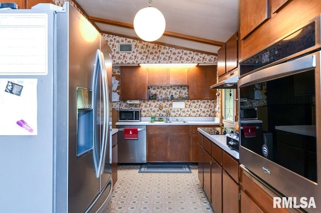 kitchen featuring a healthy amount of sunlight, hanging light fixtures, vaulted ceiling, and appliances with stainless steel finishes