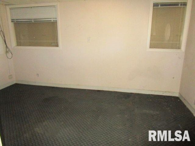 unfurnished room featuring dark colored carpet