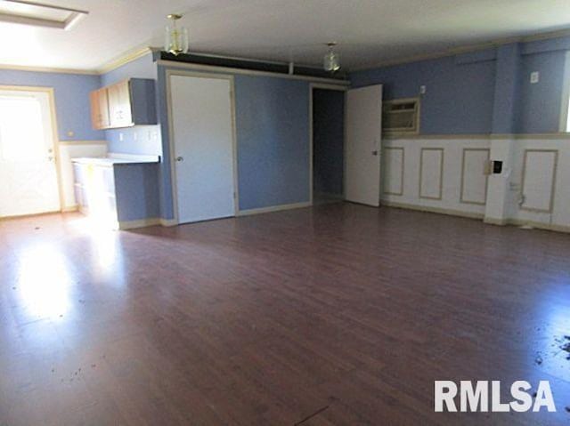 interior space with ornamental molding and dark hardwood / wood-style floors