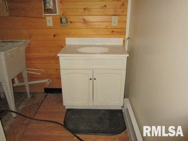 bathroom featuring vanity and wooden walls