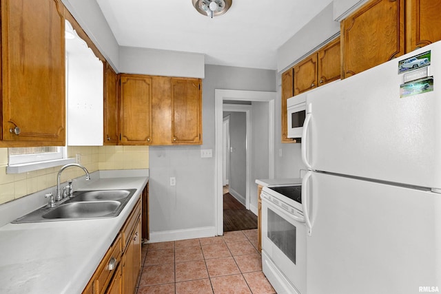 kitchen featuring decorative backsplash, white appliances, light tile patterned flooring, and sink