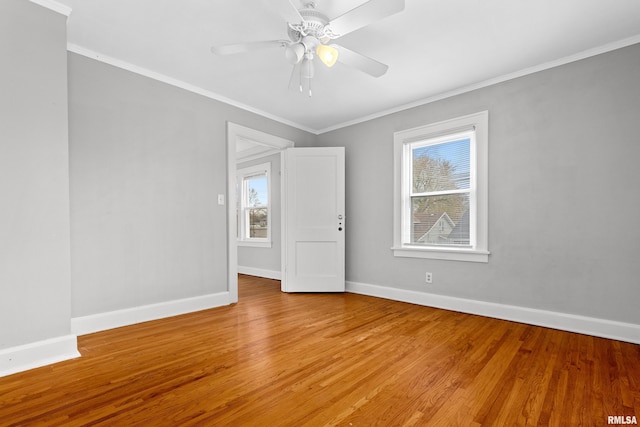 empty room with ceiling fan, wood-type flooring, and plenty of natural light