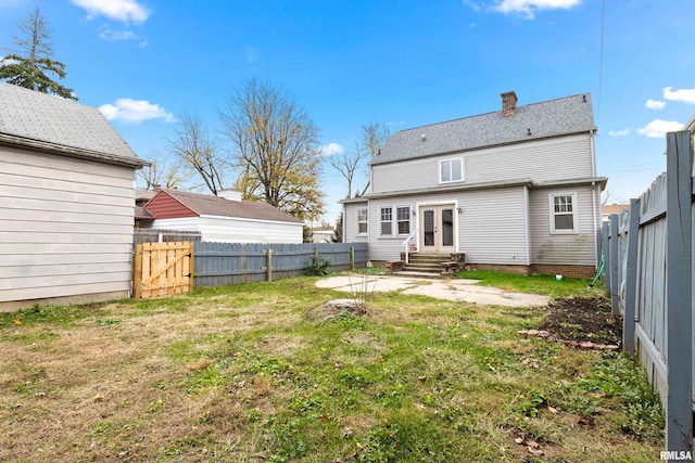 rear view of house featuring a yard