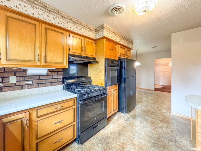 kitchen with pendant lighting, a textured ceiling, black appliances, and tasteful backsplash