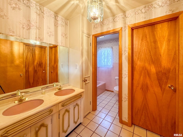 bathroom with toilet, a tub, tile patterned floors, a chandelier, and vanity