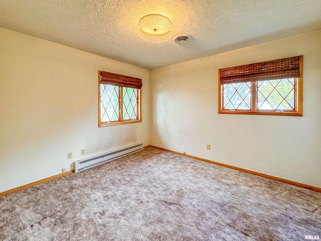 unfurnished room featuring a wealth of natural light, a textured ceiling, a baseboard heating unit, and carpet floors