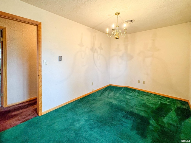 carpeted spare room with a textured ceiling and a notable chandelier