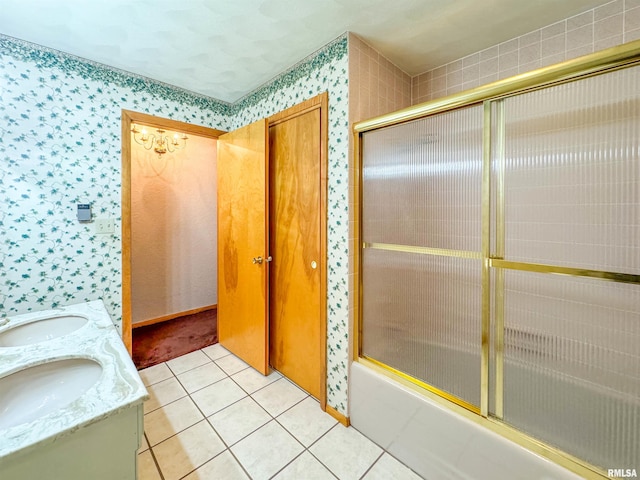 bathroom with combined bath / shower with glass door, vanity, and tile patterned flooring