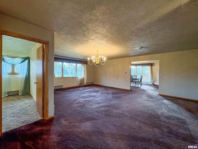 carpeted spare room featuring a chandelier, plenty of natural light, a textured ceiling, and a baseboard heating unit