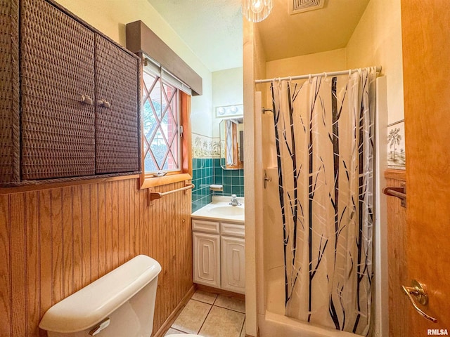 bathroom featuring tile patterned flooring, a shower with curtain, vanity, wooden walls, and toilet