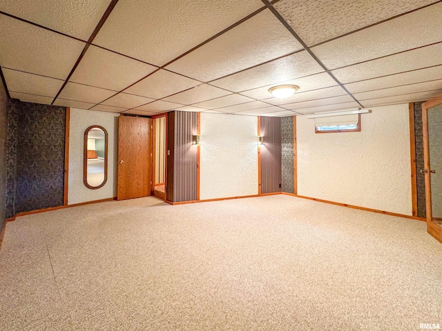 basement with a paneled ceiling and carpet flooring