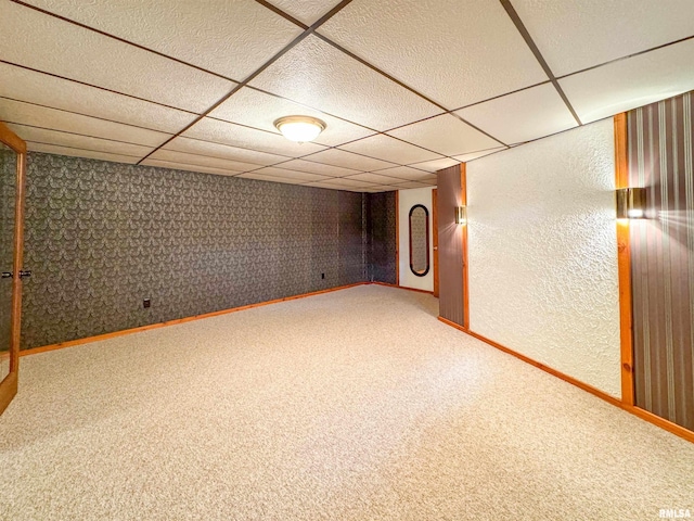 basement featuring a drop ceiling and carpet flooring