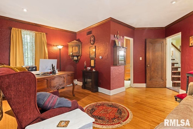 office with light hardwood / wood-style floors and ornamental molding