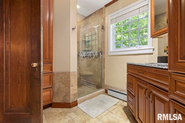 bathroom with vanity, baseboard heating, tile patterned flooring, and a shower with door