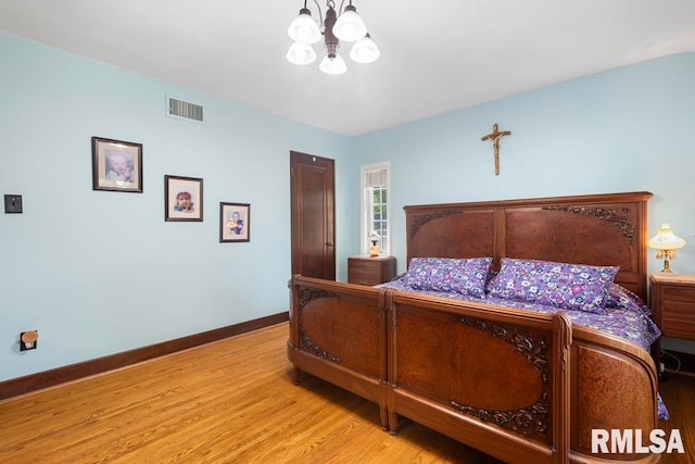 bedroom with light hardwood / wood-style flooring and a notable chandelier