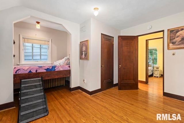 bedroom featuring light hardwood / wood-style floors and vaulted ceiling