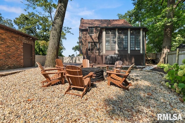 exterior space with a sunroom and a fire pit