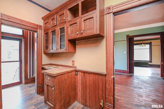 kitchen featuring wood walls, hardwood / wood-style flooring, and ornamental molding