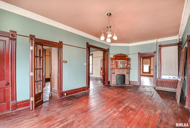 unfurnished living room with ornamental molding, hardwood / wood-style floors, radiator, and an inviting chandelier