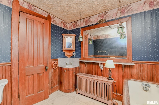 bathroom featuring vanity, radiator, and wooden walls