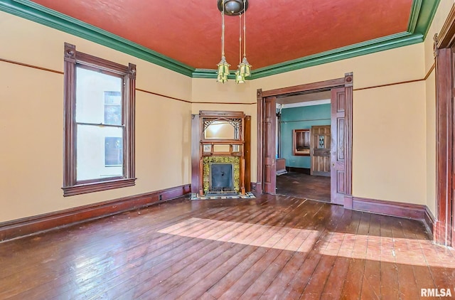 empty room featuring hardwood / wood-style floors, a high end fireplace, and ornamental molding