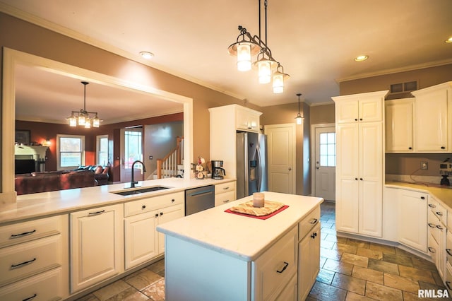 kitchen with pendant lighting, white cabinetry, sink, and stainless steel appliances