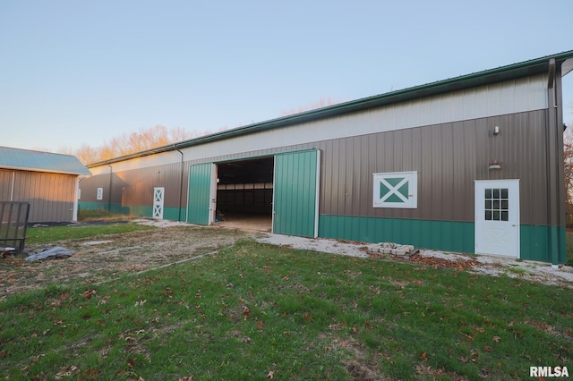 view of side of property with an outdoor structure and a yard