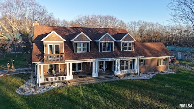 view of front of property featuring a patio area, a balcony, french doors, and a front lawn