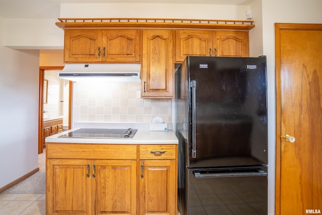 kitchen featuring light tile patterned floors, decorative backsplash, and black appliances