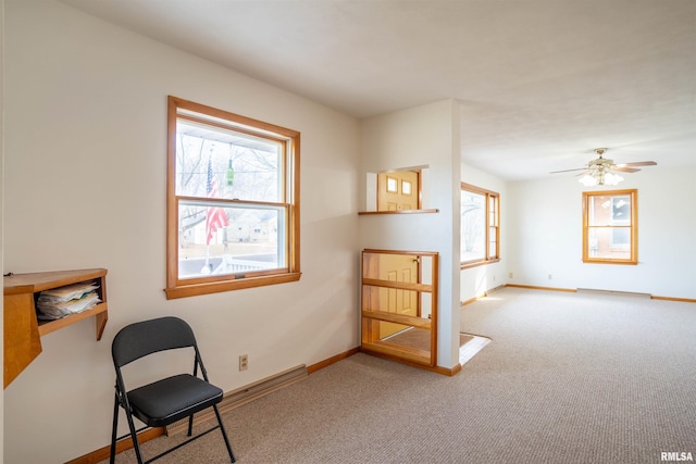 sitting room featuring a healthy amount of sunlight, light colored carpet, and ceiling fan