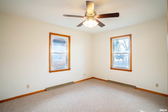 carpeted spare room with a baseboard heating unit and ceiling fan