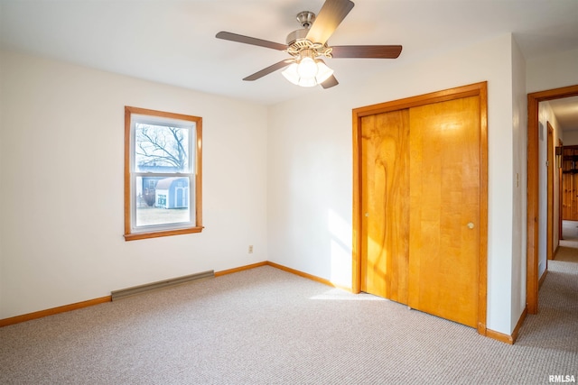 unfurnished bedroom with a closet, ceiling fan, and carpet