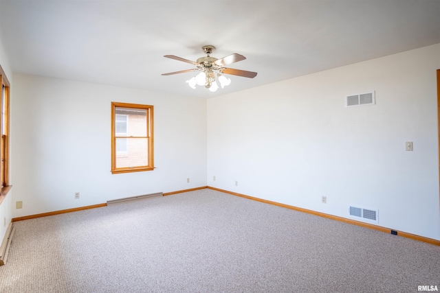 empty room featuring ceiling fan and carpet