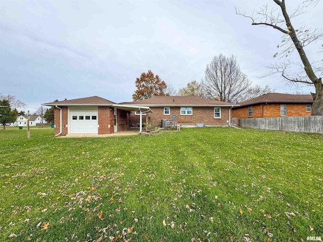 back of property featuring a garage, a yard, and central AC