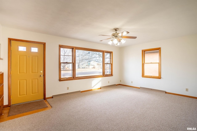 carpeted entrance foyer with a baseboard heating unit and ceiling fan